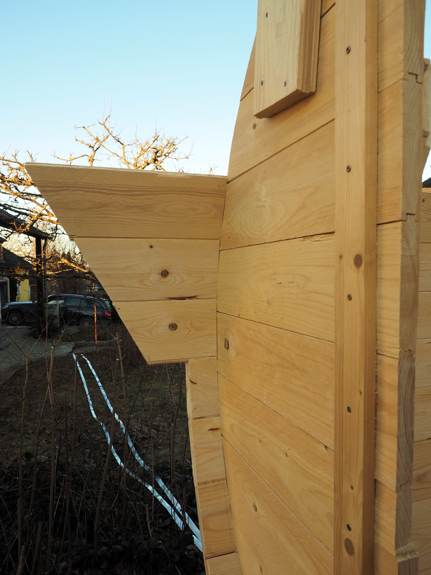 Beim Setzen der Bretter wird die nach außen verlängerte Dachschräge sichtbar, die vor Schlagregen schützt.