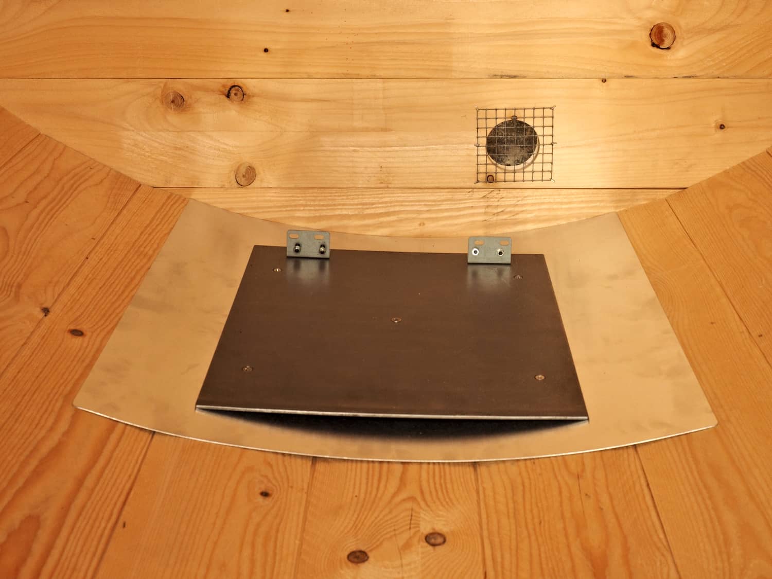 Der Ofen steht auf einem dicken Stahlblech, das Ofenrohr wird mit einer Flex auf Maß gekürzt.